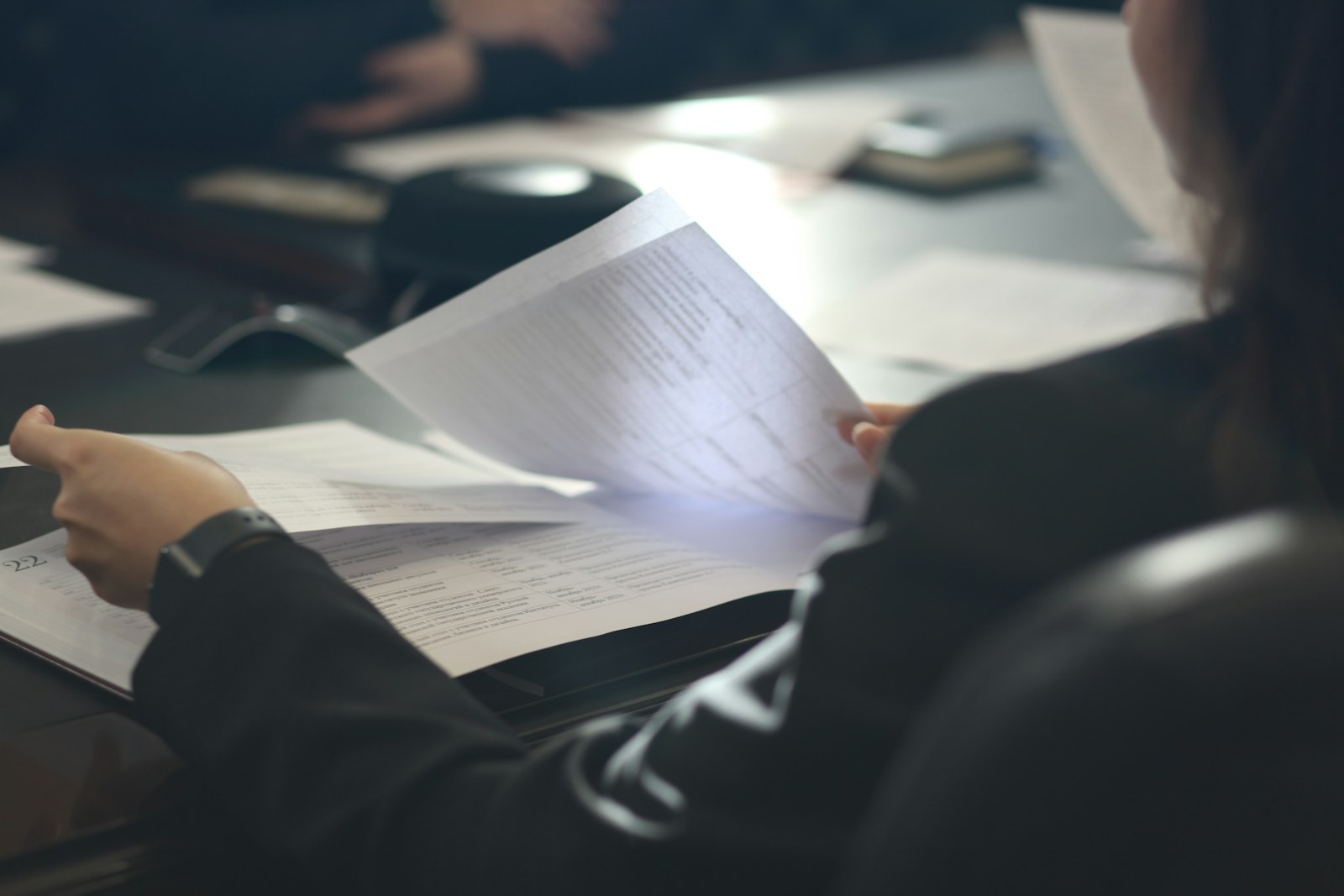 Professionista che esamina documenti e banche dati per una ricerca di anteriorità del marchio